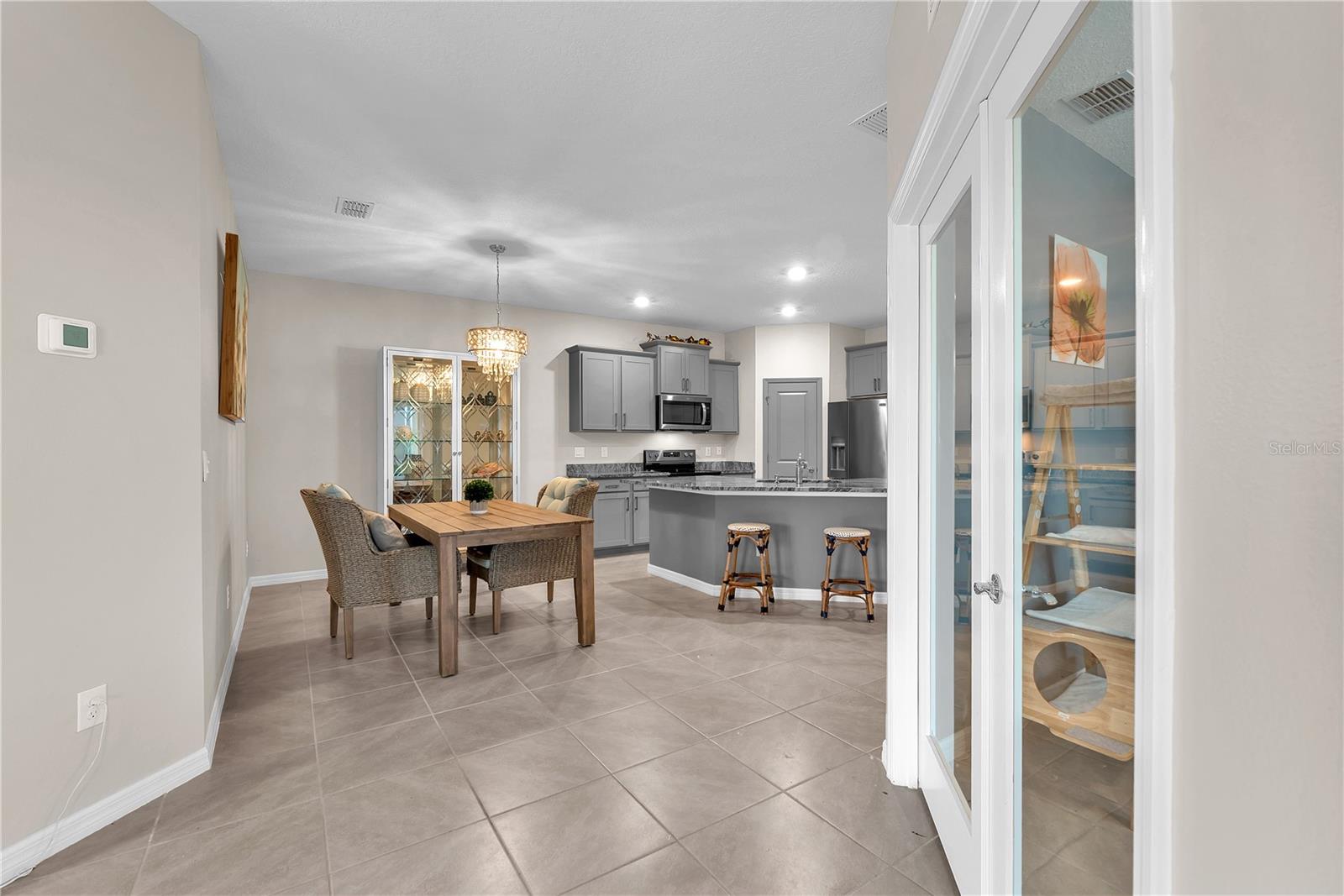 Inside, you'll find a bright and inviting floor plan with abundant natural light, neutral décor, and durable tile flooring throughout the main living areas.