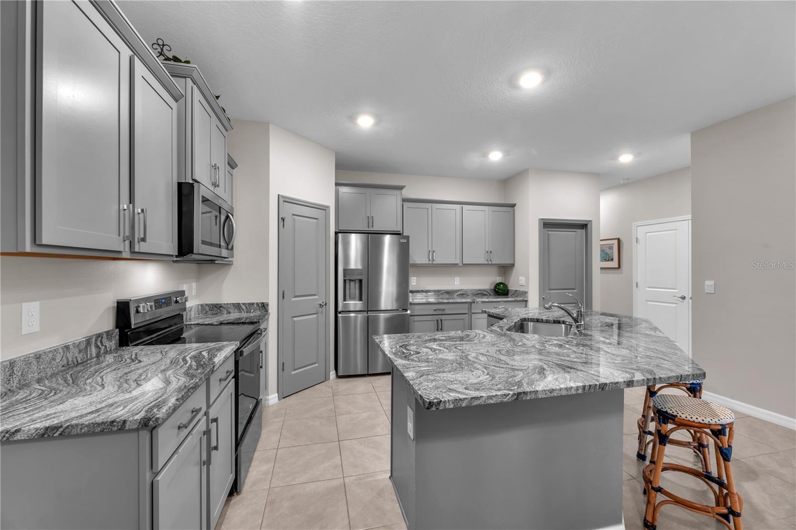 The stylish kitchen is designed for both function and beauty, featuring granite countertops, stainless steel appliances, and lots of cabinetry.