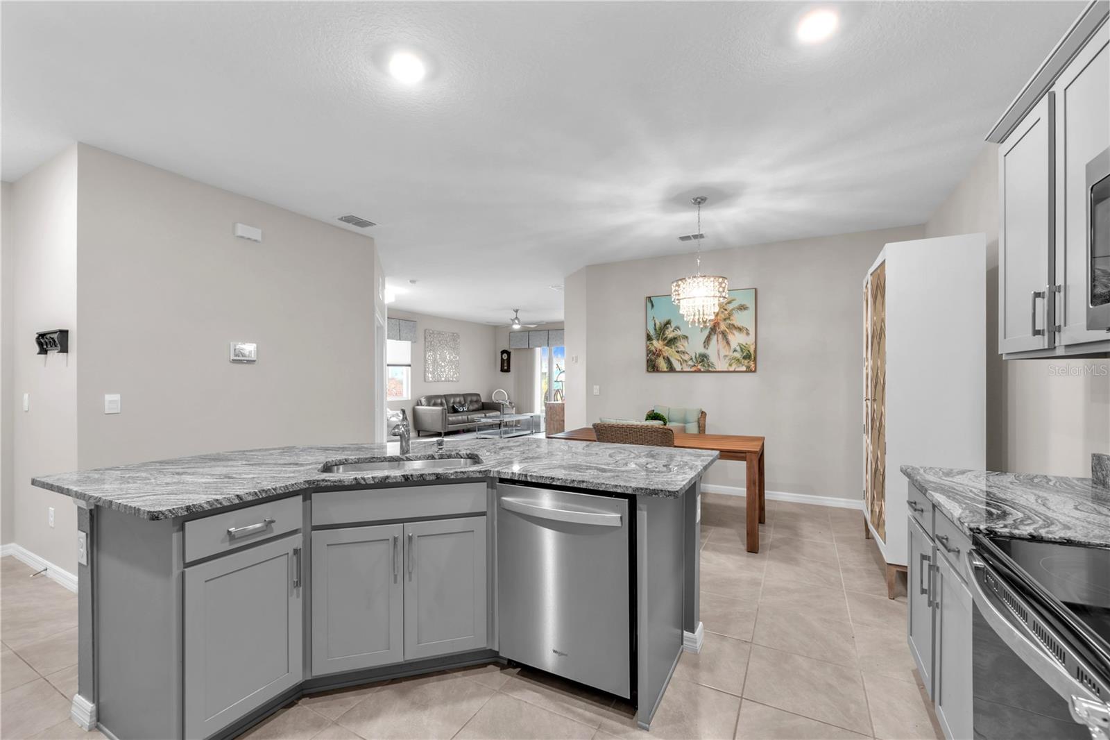 The spacious island overlooking the living and dining areas has sink and dishwasher and additional counter height seating for guests to keep everyone connected.