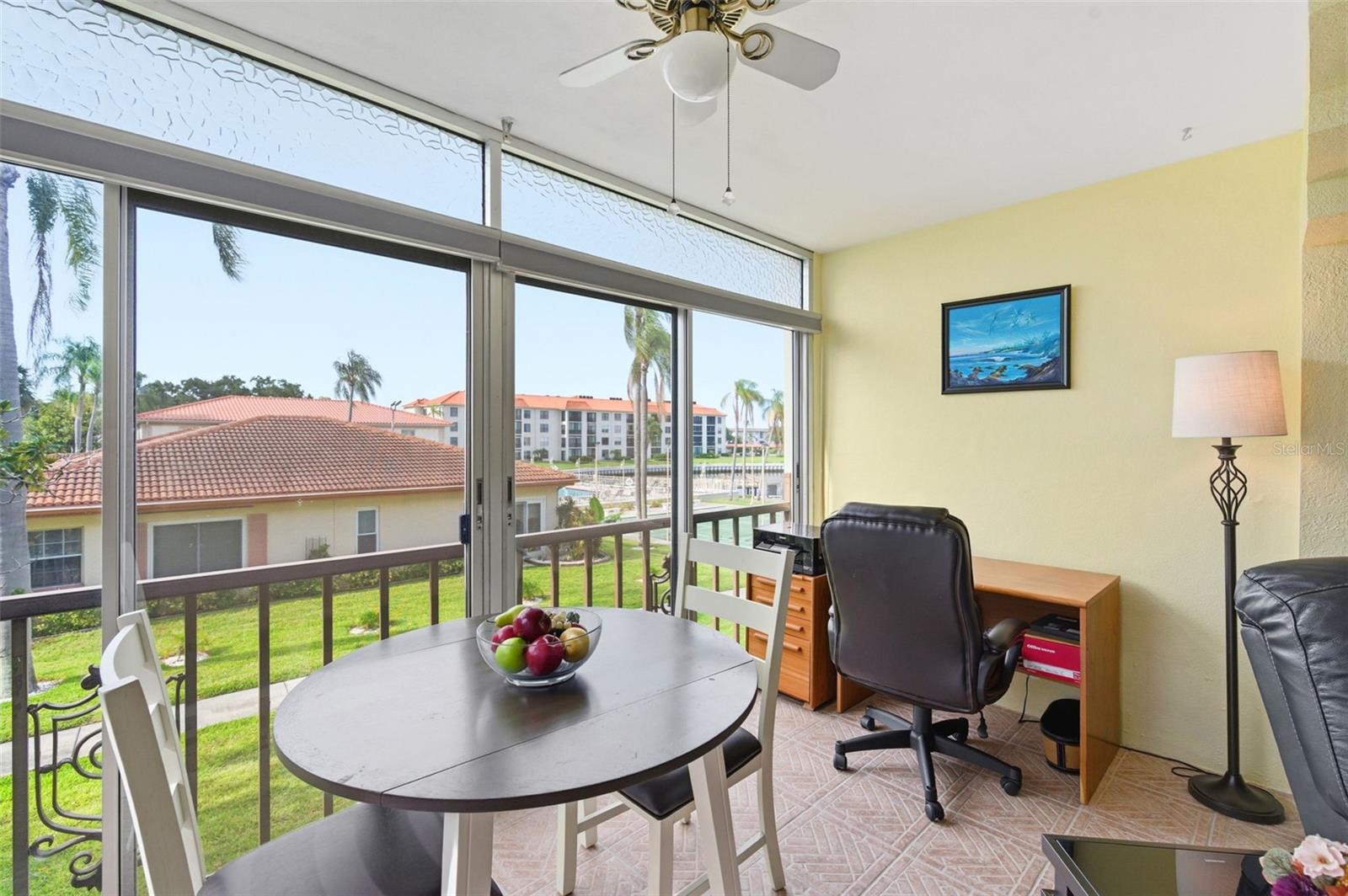 Florida Room off of Living Room with views of the water, pool, and community amenities.