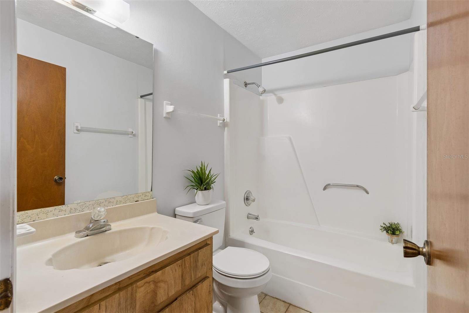 Secondary bathroom is situated down the secluded hallway with the secondary bedrooms.
