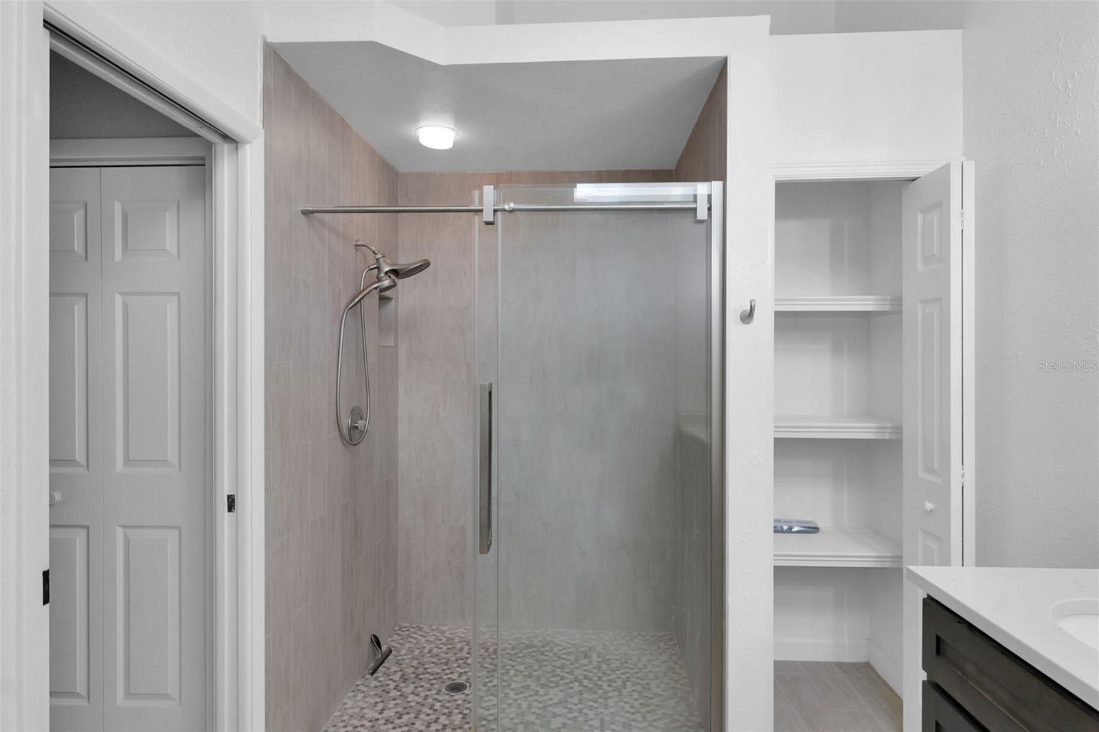 Main bath with stand up shower only, double vanities, granite countertops, linen closet