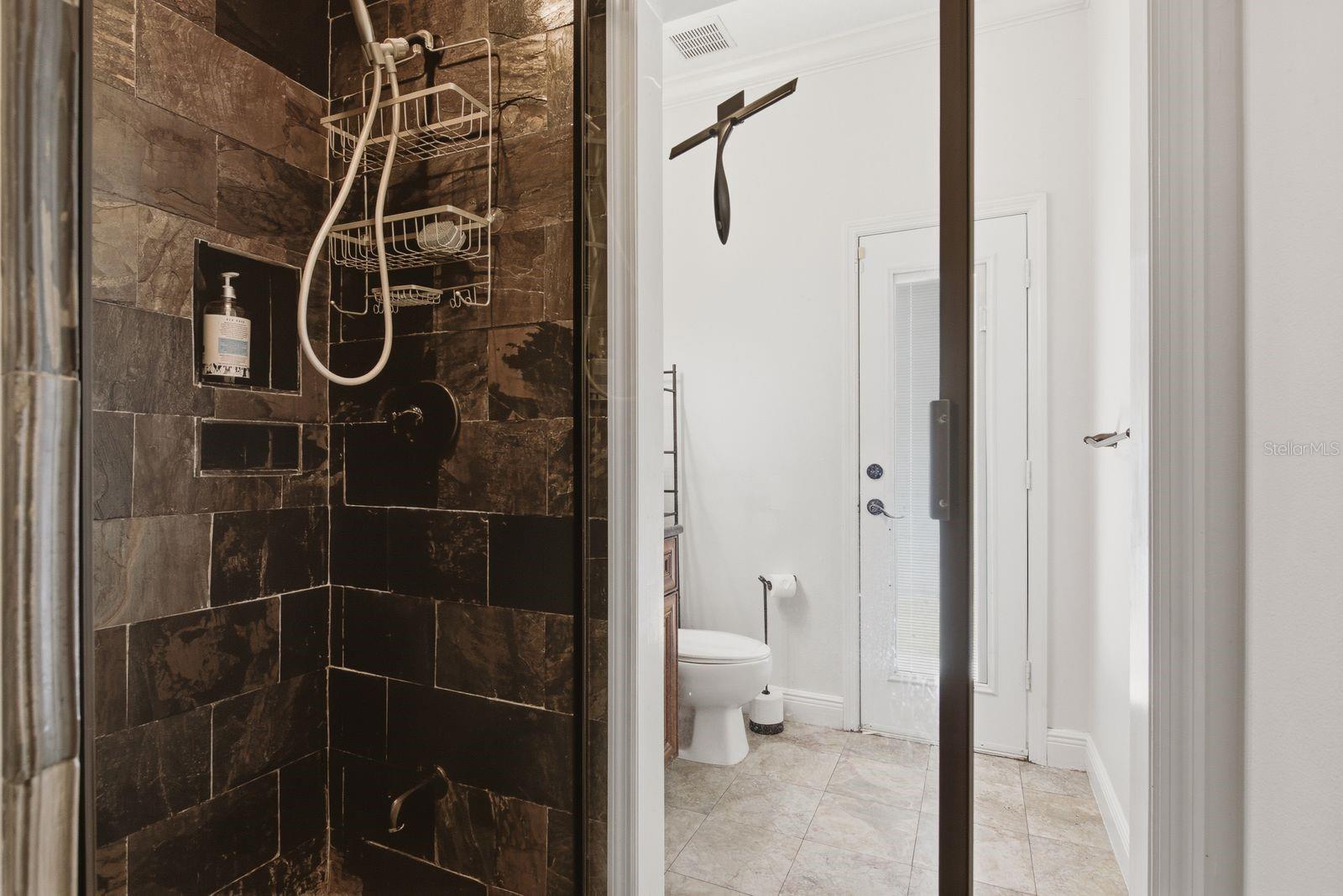 bathroom with walk in shower and  exterior exit to pool area/ or walk way to front