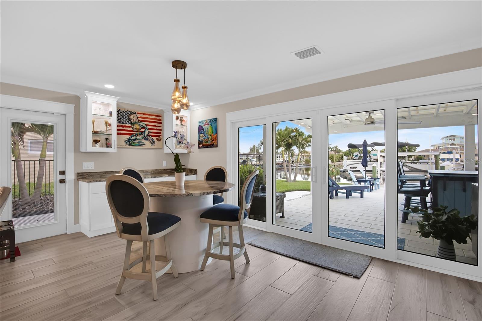 DINING TABLE - WATER VIEWS ABOUND.  DRY BAR - LIGHTED CABINETS -  PGT DOUBLE SLIDERS = NEW - SIDE DOOR TO THE OUTSIDE GRILL AREA