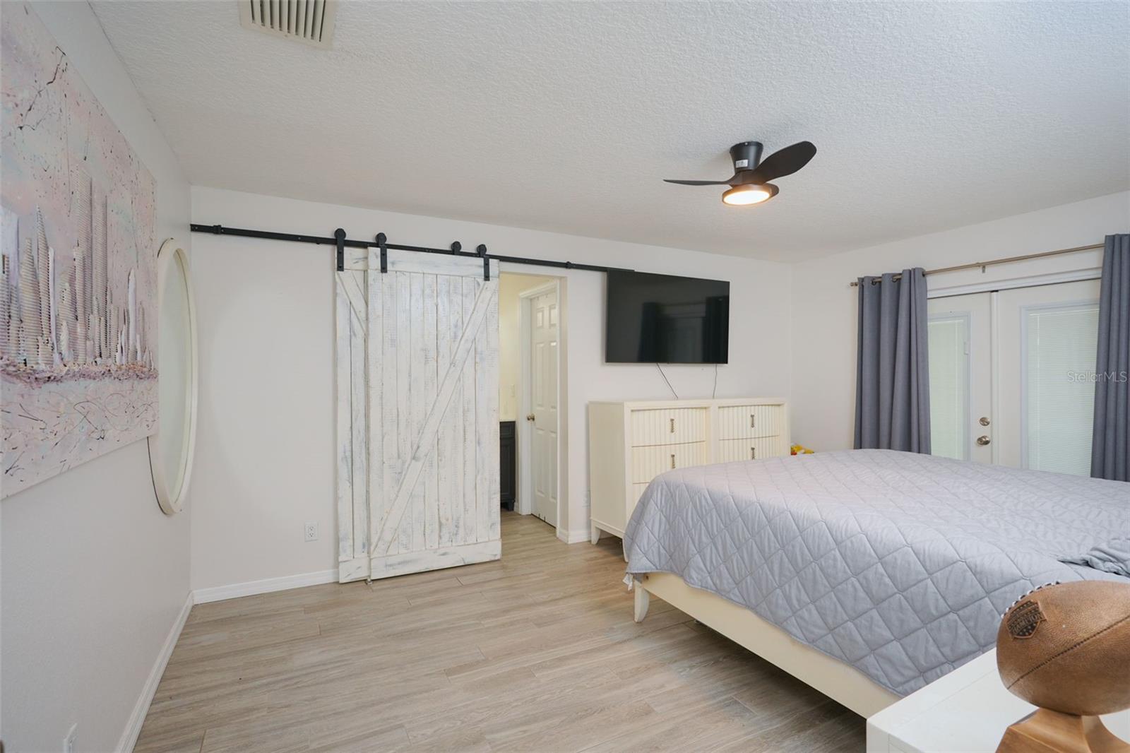 Primary Bedroom with Barn doors leading to bathroom and walk in closet