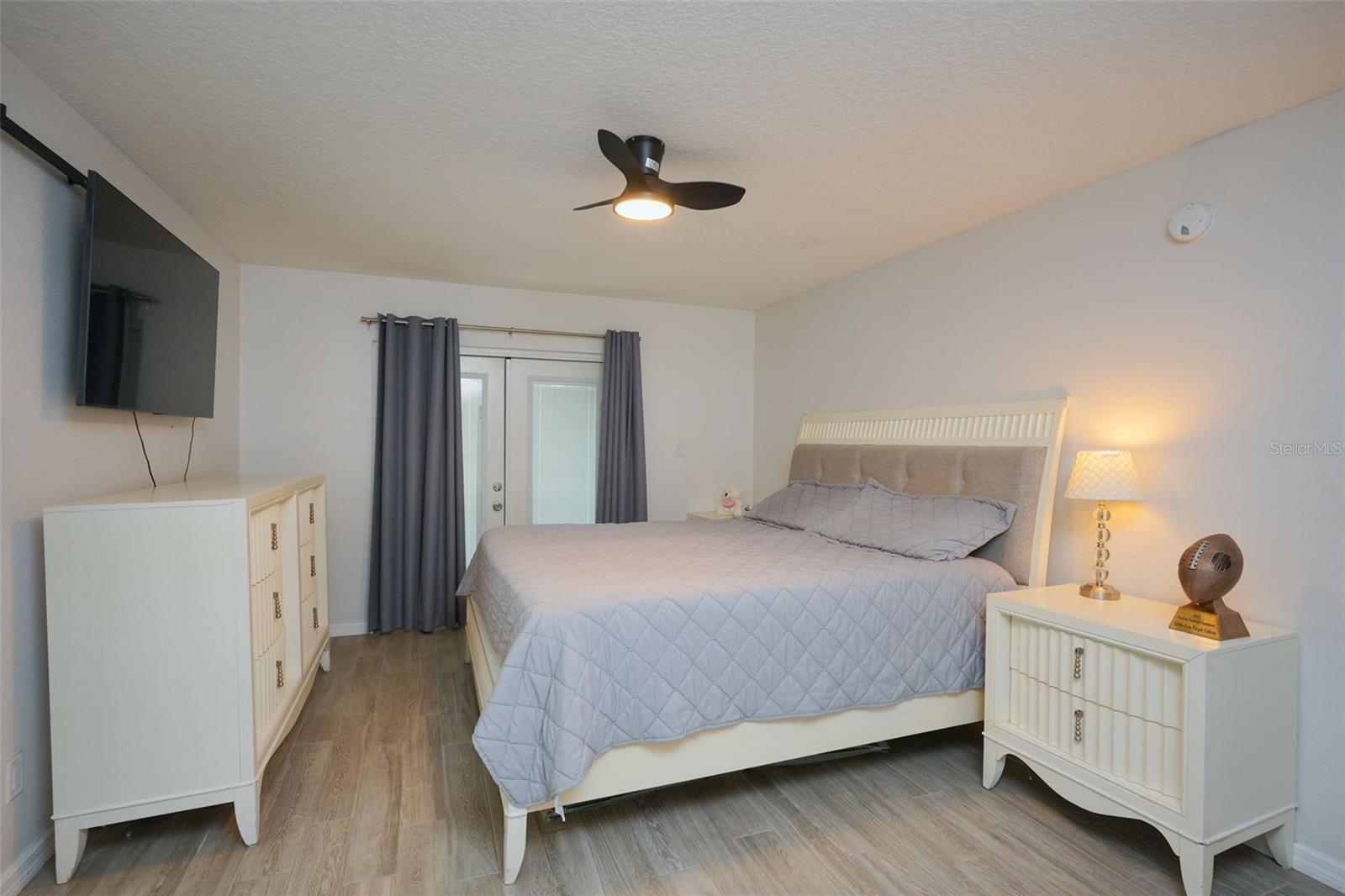 Primary bedroom with French doors leading to back yard.
