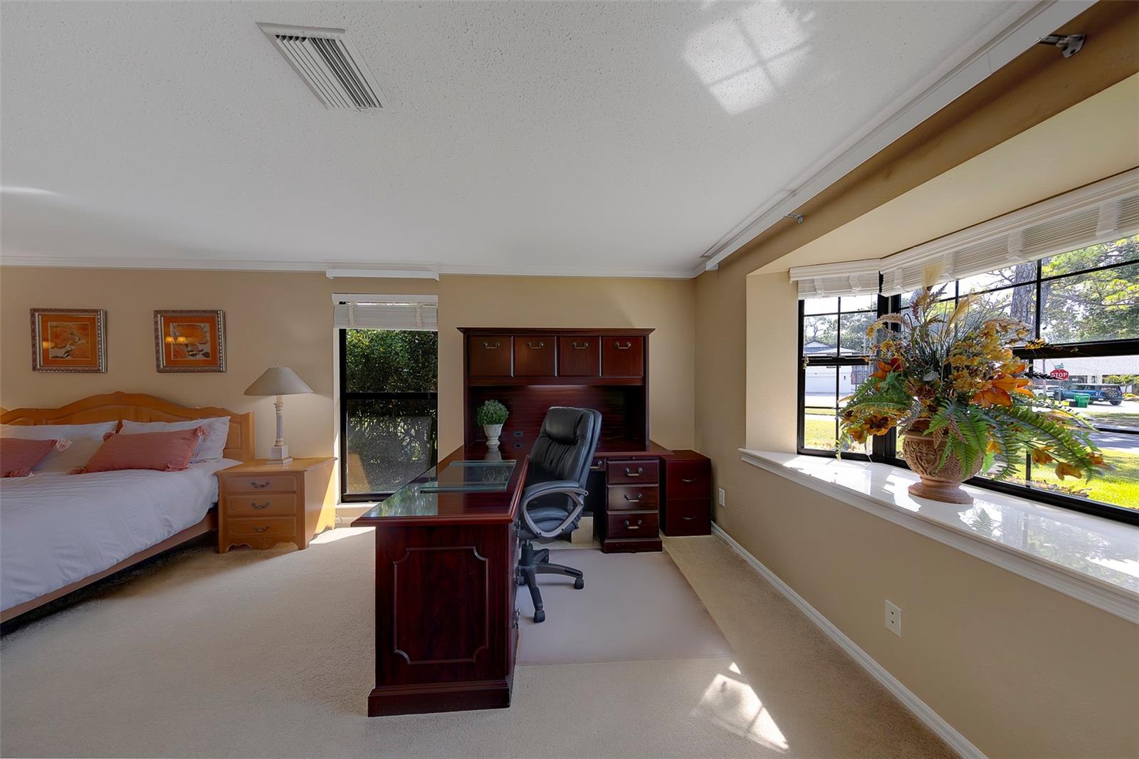 Could be a small office or sitting area. Nice Bay Window accents the master