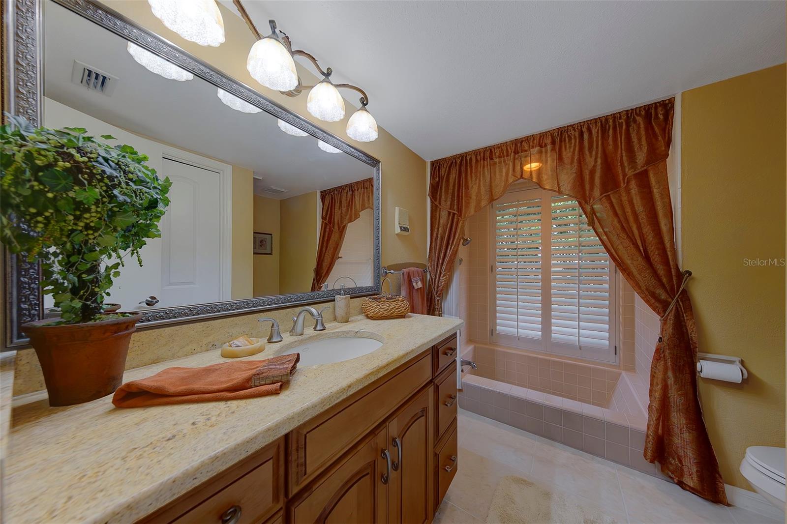 Bathroom 2 features a sunken tub and shower with plantation shutters