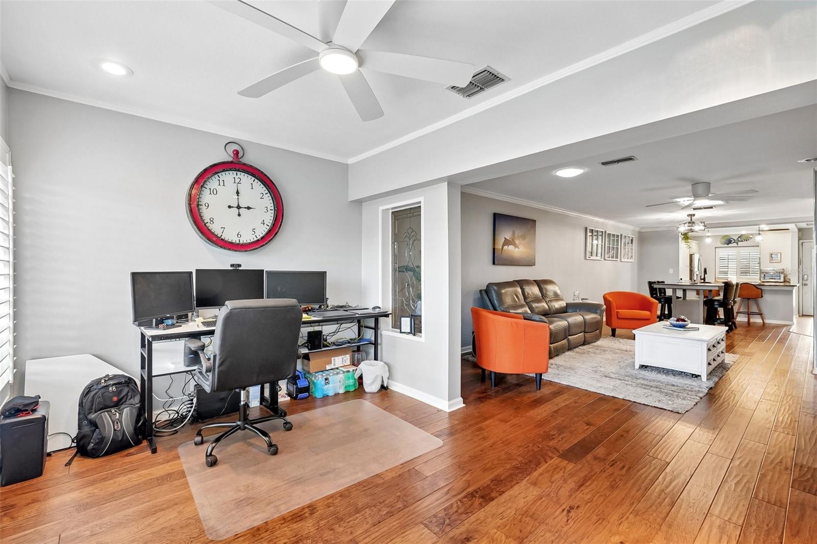 Sunroom / flex space with wall of windows dressed with Key West style plantation shutters is ideal for office, morning coffee, reading or just relaxing.
