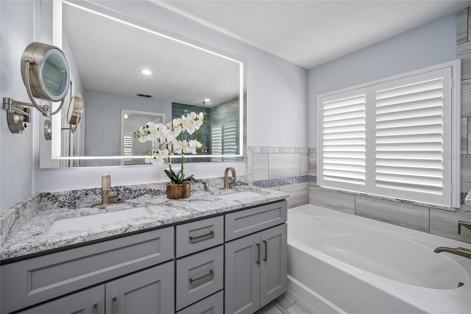 Remodeled primary bath with soaking tub and frameless glass shower