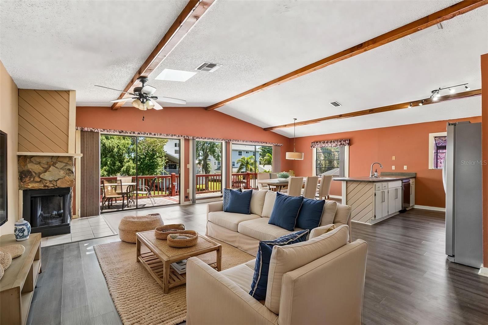 Fabulous open floor plan, with vaulted ceilings, decorative wood beams, skylight, luxury vinyl floors and fireplace.