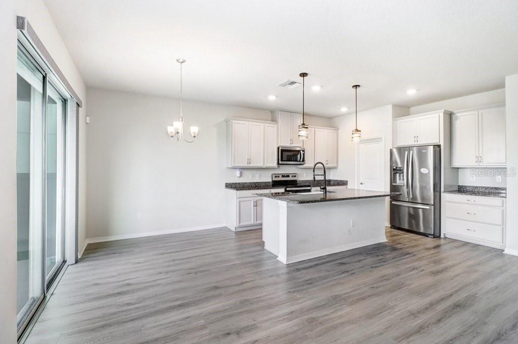 Kitchen with 42" cabinets, island with farm sink, granite and stainless appliances