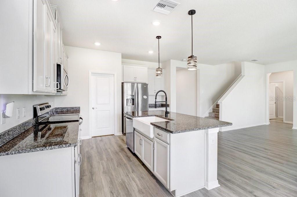 Kitchen with 42" cabinets, island with farm sink, granite and stainless appliances