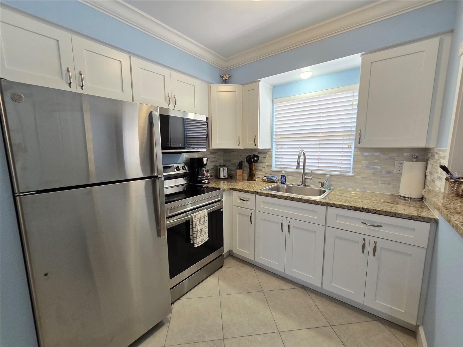 The kitchen has brand new stainless steel appliances, granite counters and quality wood cabinets with soft close doors.  All kitchen equipment, pots, pans and silverware convey.