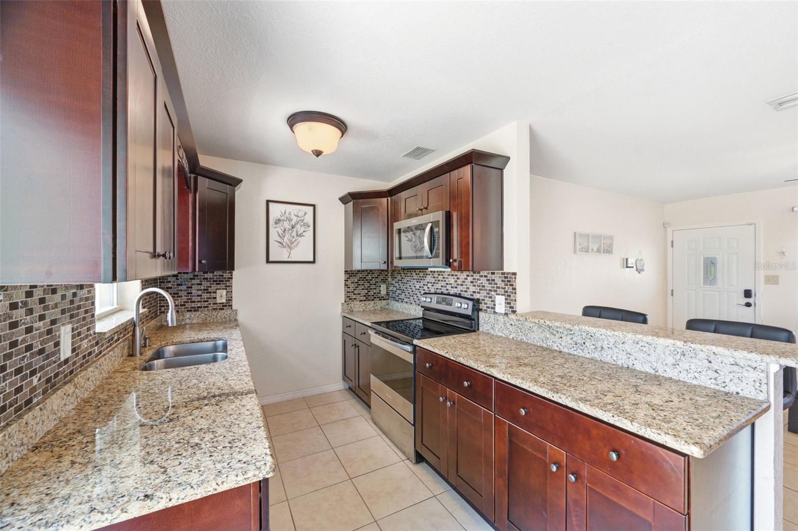 Granite countertops, stainless steel appliances and access to the Backyard through sliding doors.
