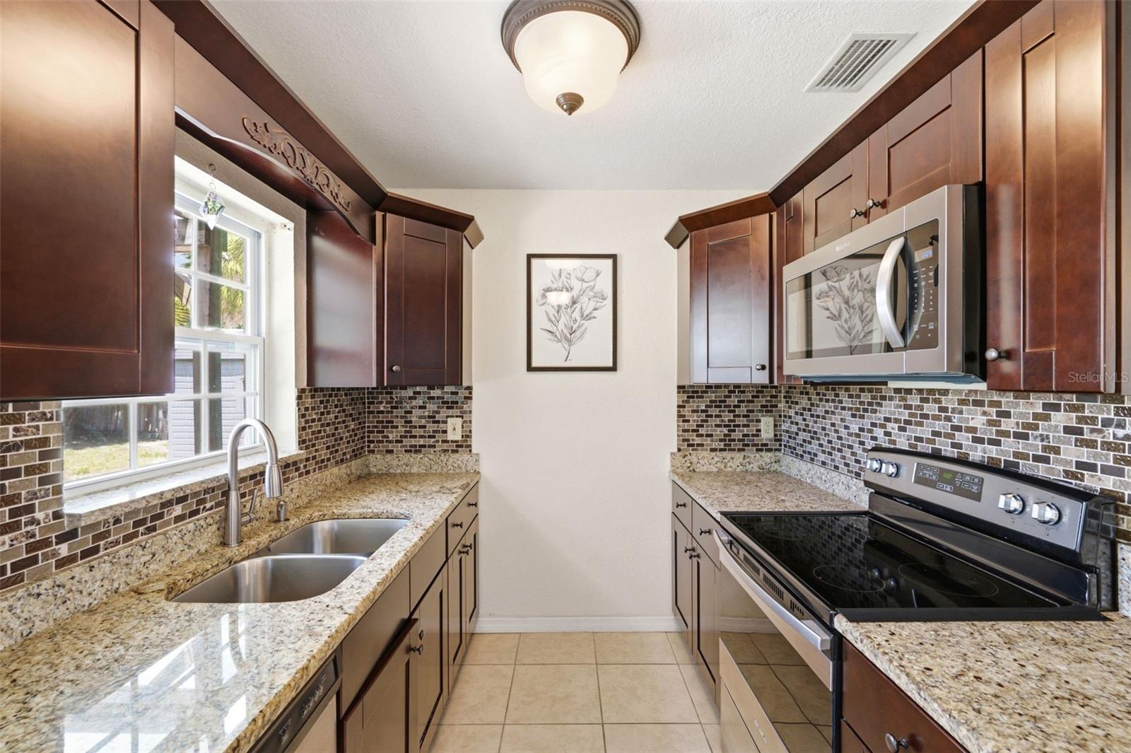 Bright Kitchen with window above sink letting sunshine in and providing a view of the Backyard.