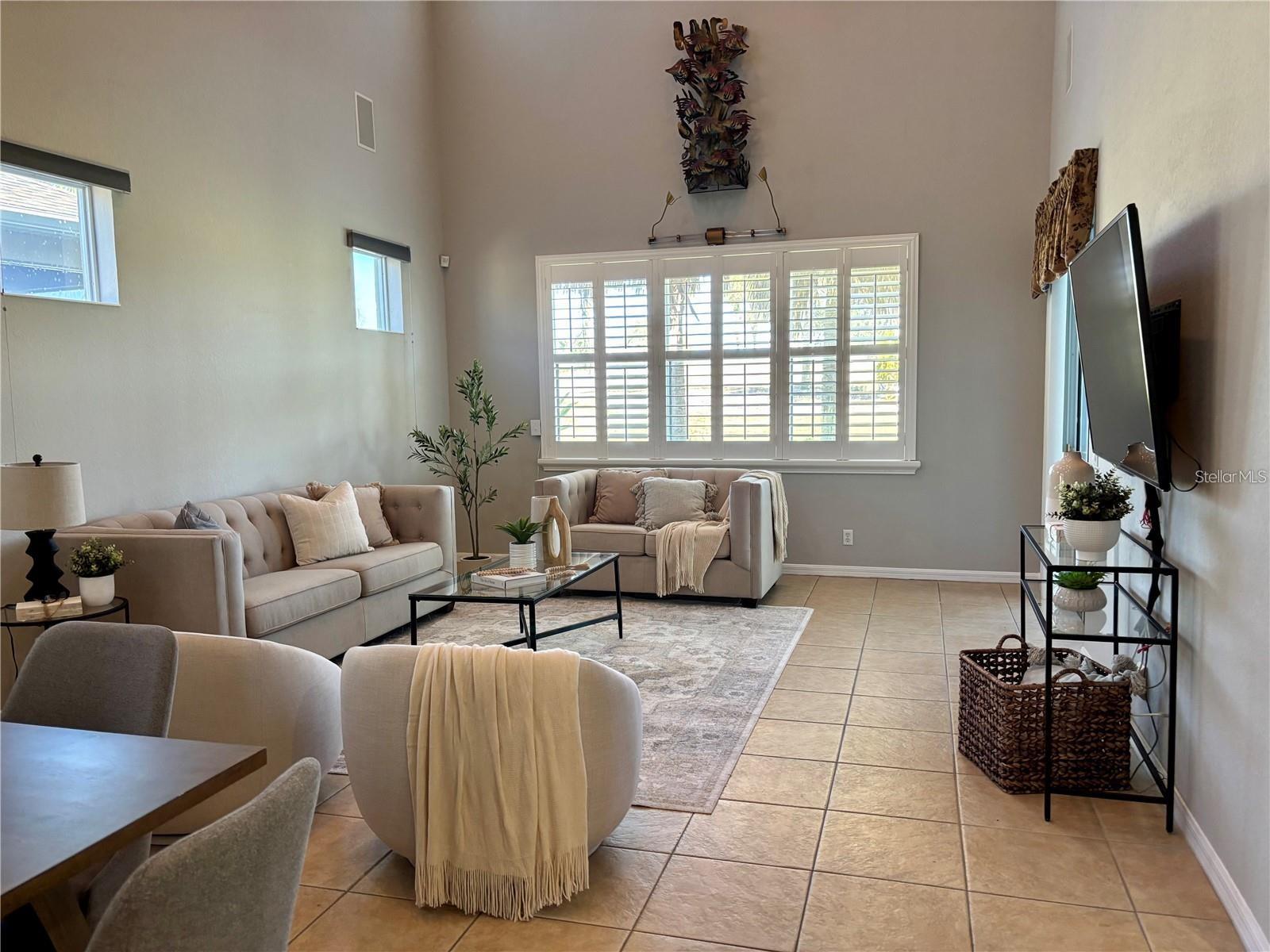 Living Room with plantation shutters and TV and surround sound stays.