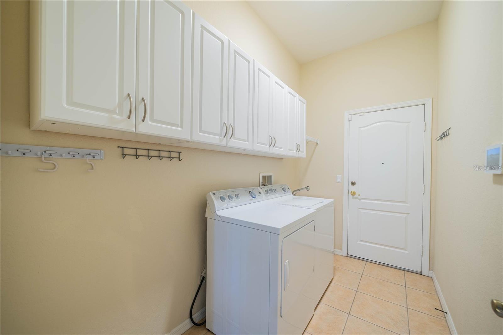 Spacious laundry room with washer and dryer included, plenty of storage, and natural light.