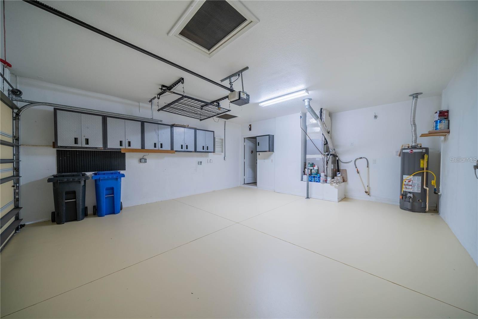 Spacious garage with Gladiator steel cabinets and above storage rack.