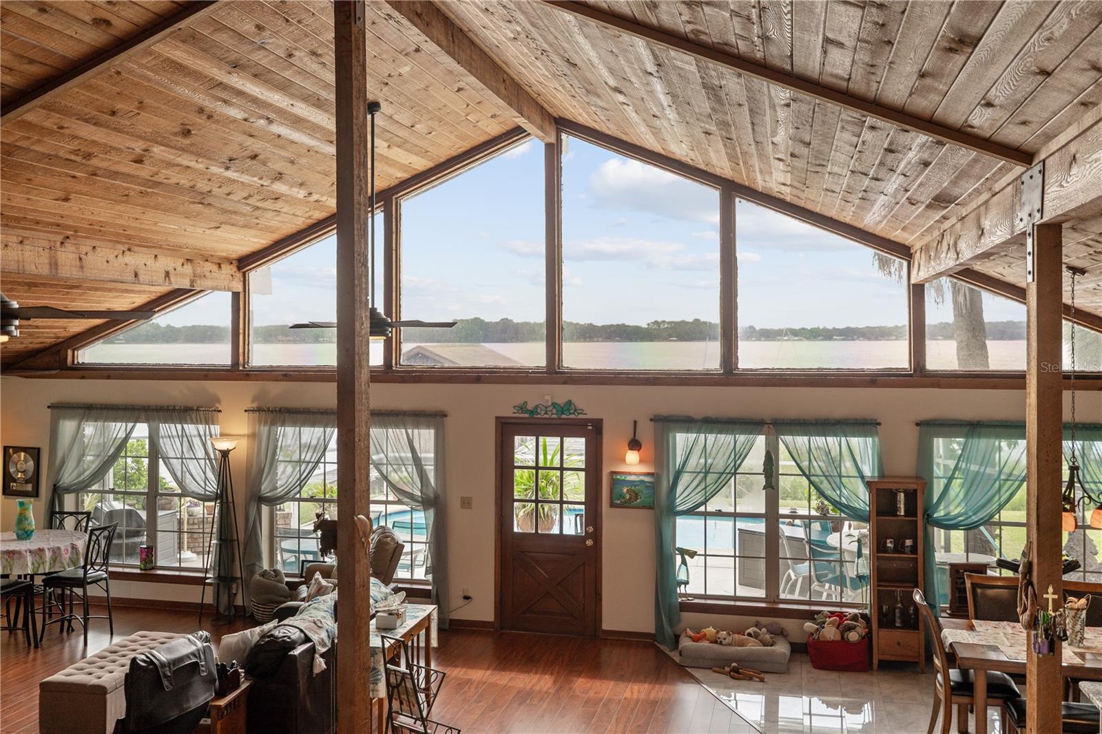 Cathedral Ceilings with Exposed Beams and Expansive Waterfront Views