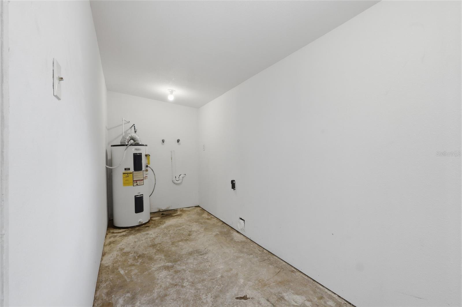 Utility room with washer and dryer hook up and room for storage racks.
