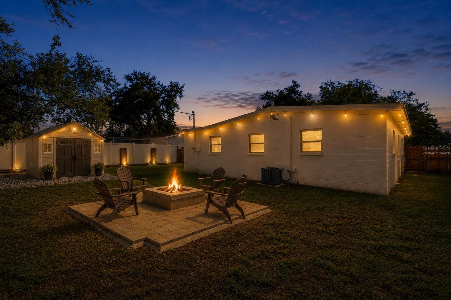 Virtually staged backyard with a shed and lighting.