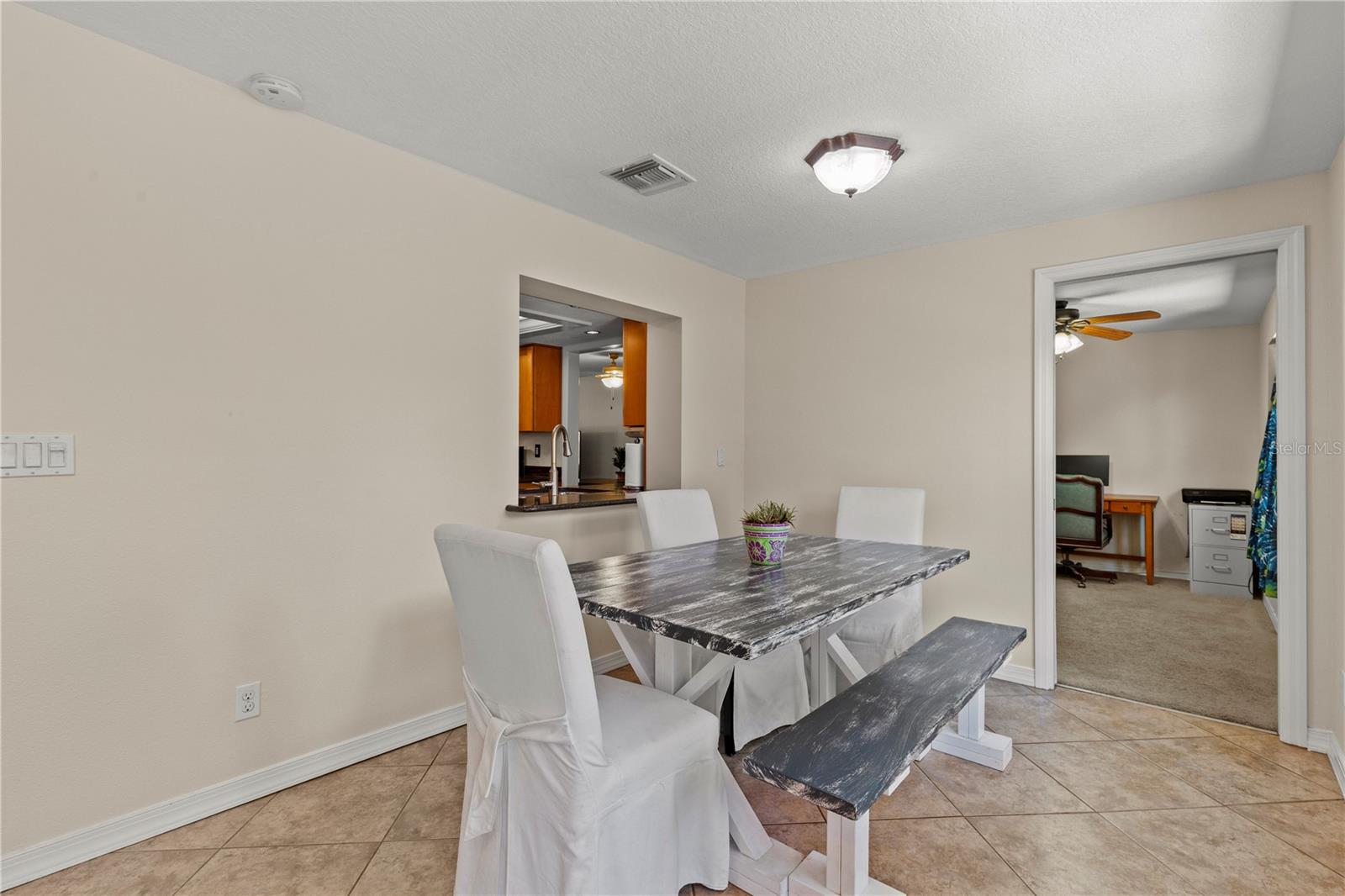 Bright Florida room offering flexible living space and convenient access to the fourth bedroom, making it ideal for use as a home office, guest suite, playroom, or private retreat. Natural light fills the space, creating a welcoming and versatile extension of the home
