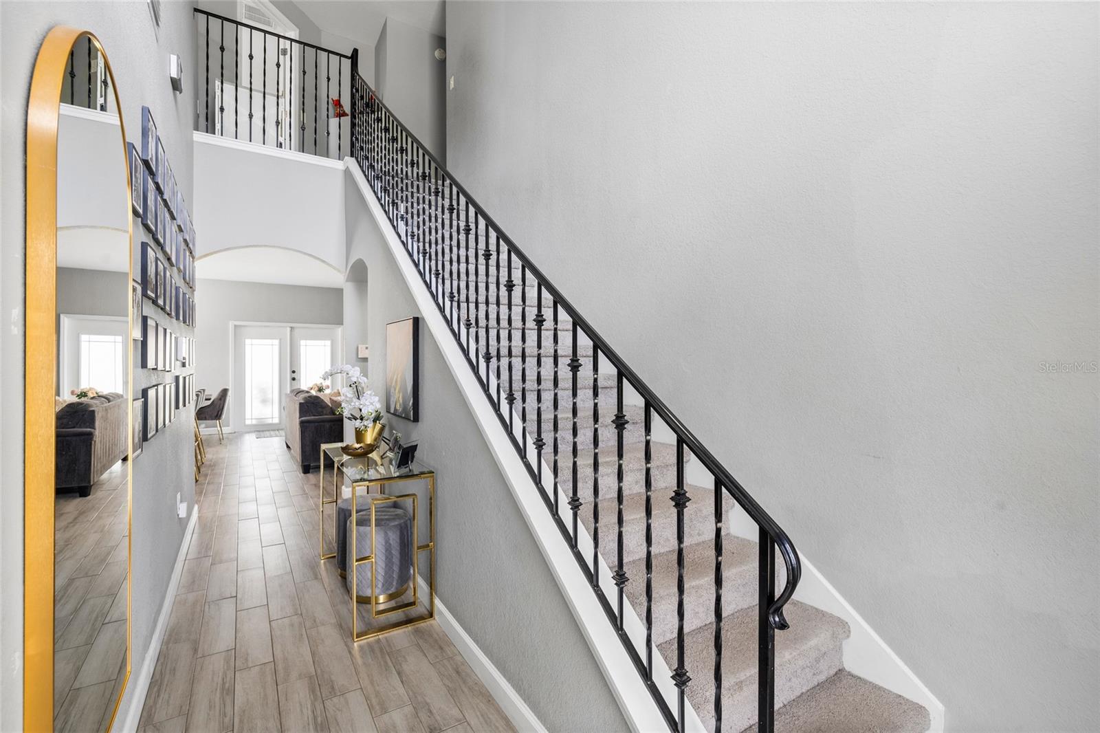 Grand entryway featuring soaring ceilings, abundant natural light, and an open-concept floor plan.