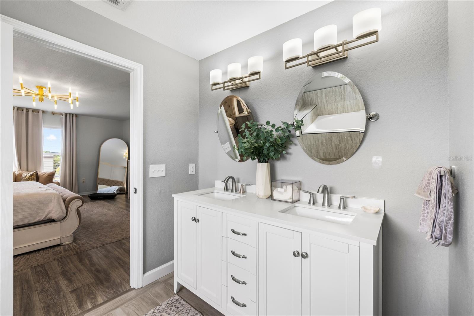 Updated primary bathroom featuring dual vanities, modern finishes, and a spacious layout.