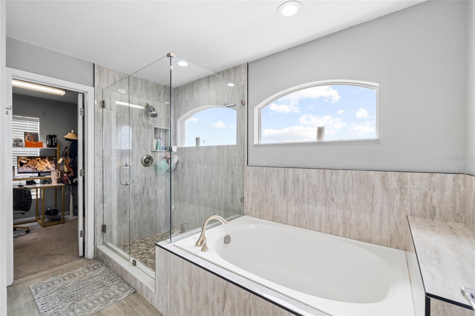 Updated primary bathroom featuring dual vanities, modern finishes, and a spacious layout.