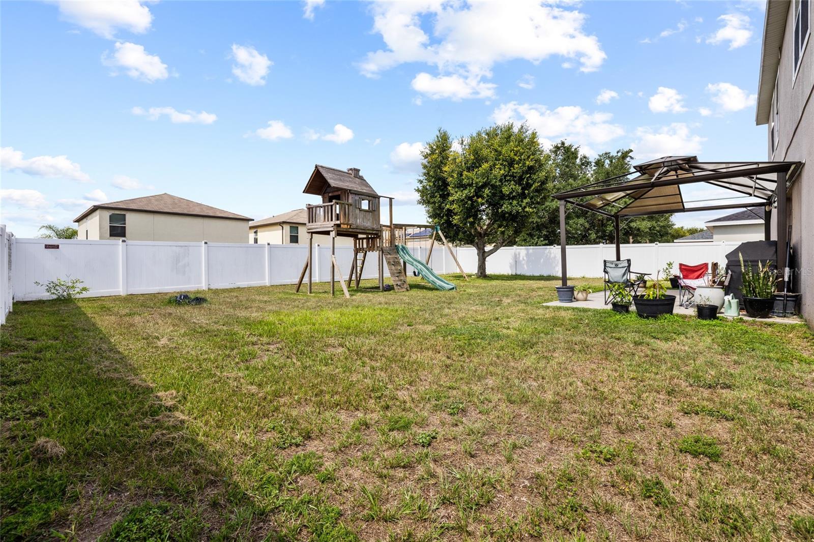 Expansive fenced backyard with plenty of room for entertaining, pets, outdoor activities, or a future pool.