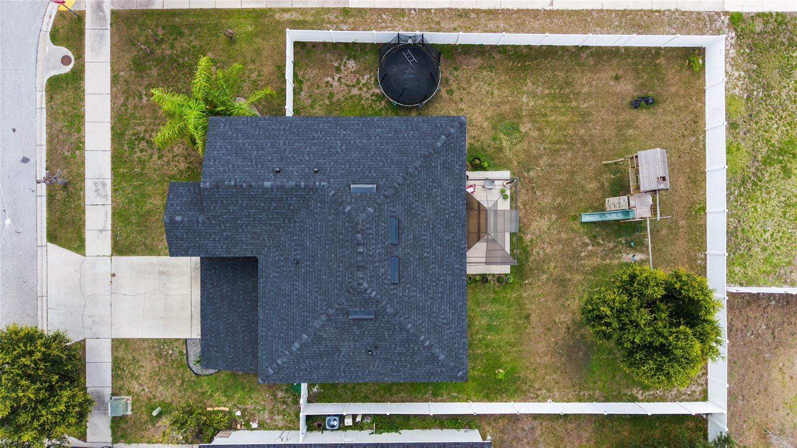 Drone shot Expansive fenced backyard with plenty of room for entertaining, pets, outdoor activities, or a future pool.