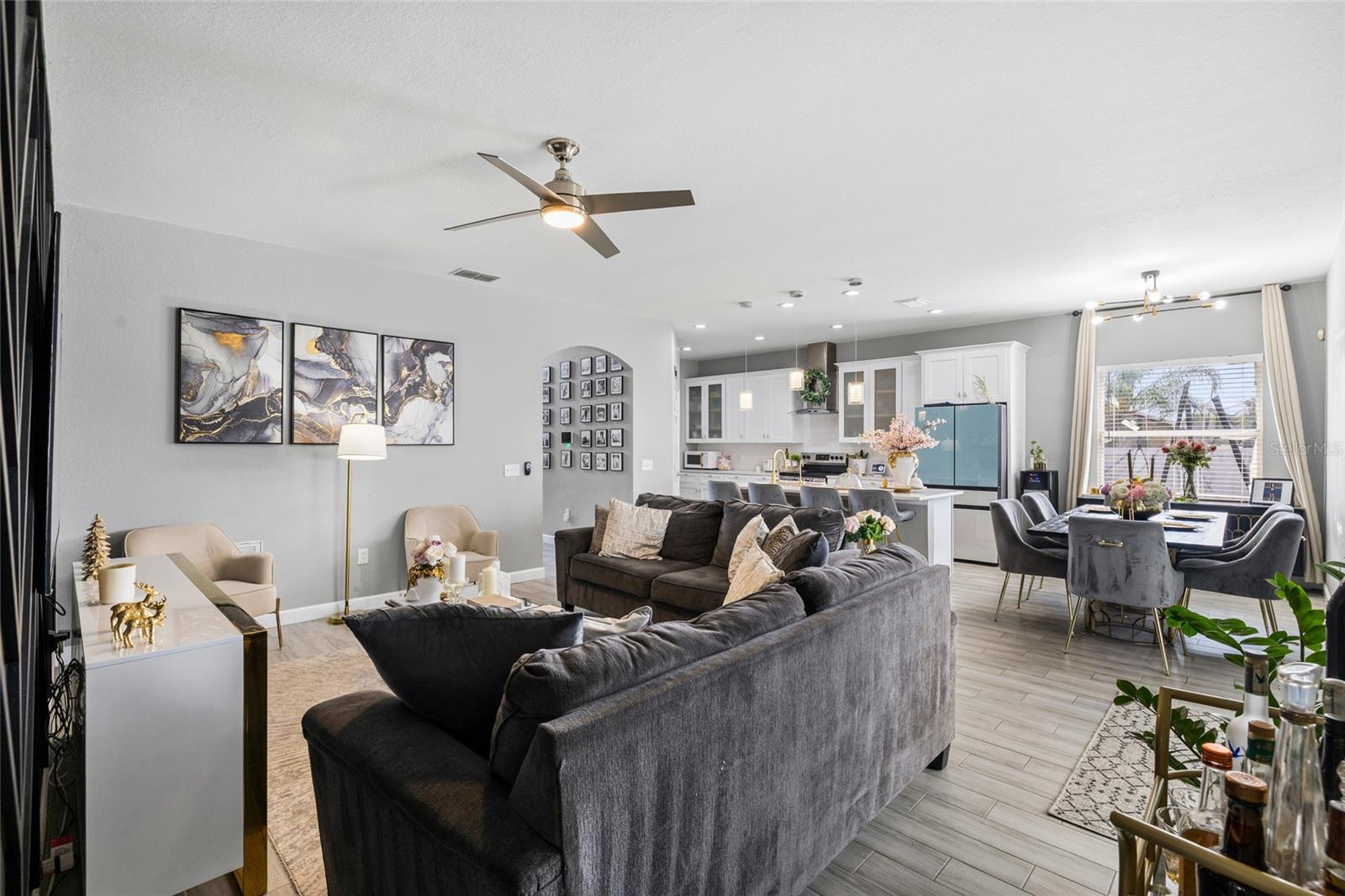 Spacious open-concept living room with designer accent wall and seamless flow to the kitchen and dining areas.