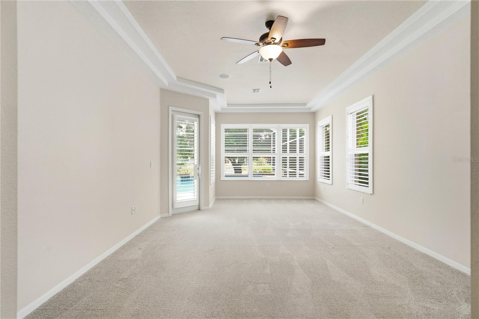 primary bedroom w/ view of lake & sitting area