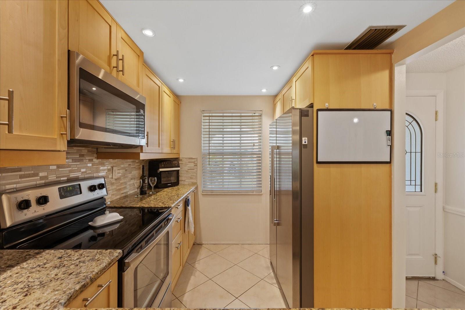Galley kitchen with storage closet and extra pull out for trash bin