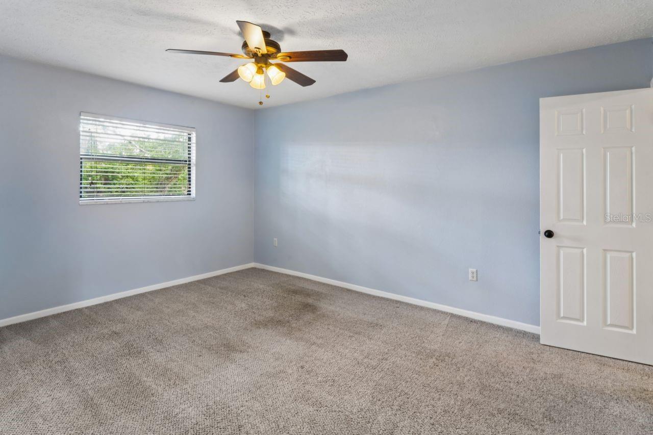 Bedroom has ceiling fan and a walk in closet.