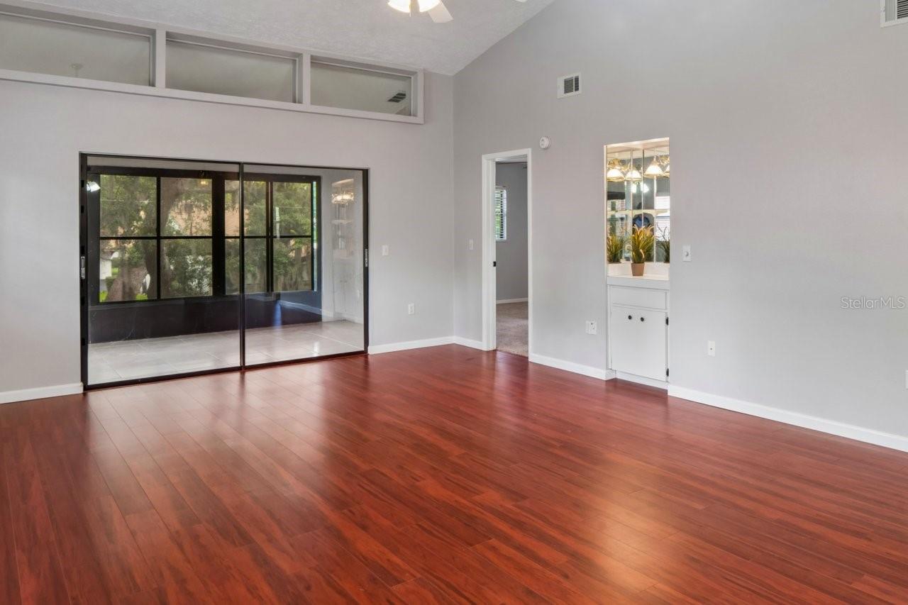 Living Room has a dry bar, laminate flooring, slider to the lanai.