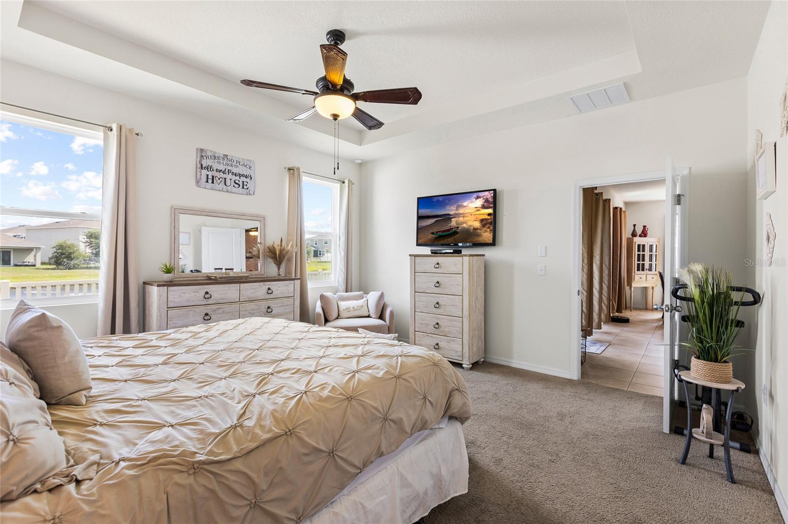 Retreat to the spacious primary suite, featuring tranquil pond views, generous room dimensions, and dual walk-in closets. The private owner's retreat provides a peaceful setting while offering plenty of storage and flexibility for large furniture arrangements.