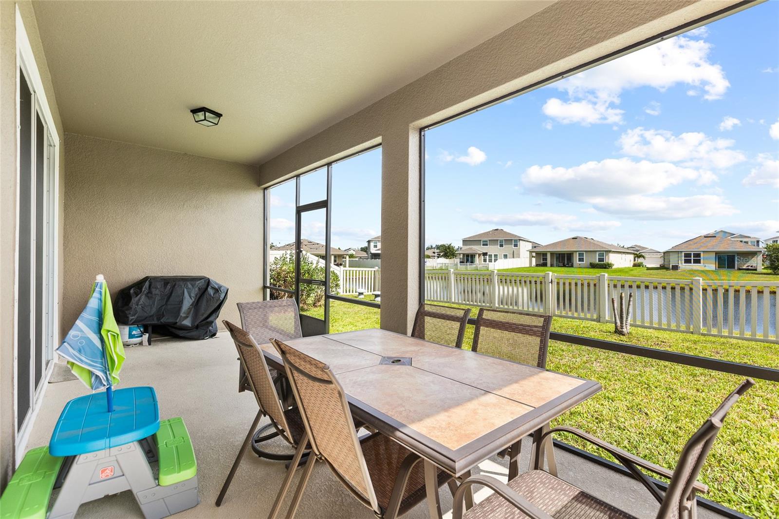 Enjoy Florida living year-round from the covered and screened lanai overlooking the pond. Whether you're enjoying your morning coffee, hosting friends, or unwinding after a long day, this outdoor living space provides beautiful water views and protection from the elements while maximizing your enjoyment of the outdoors.