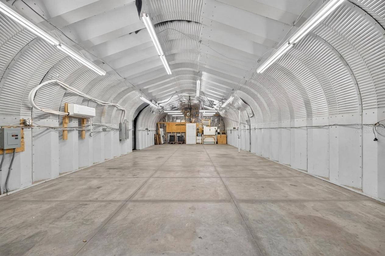 *Virtually Staged Empty* Larger garage with higher ceiling, A/C, water, electric and workshop in the back.