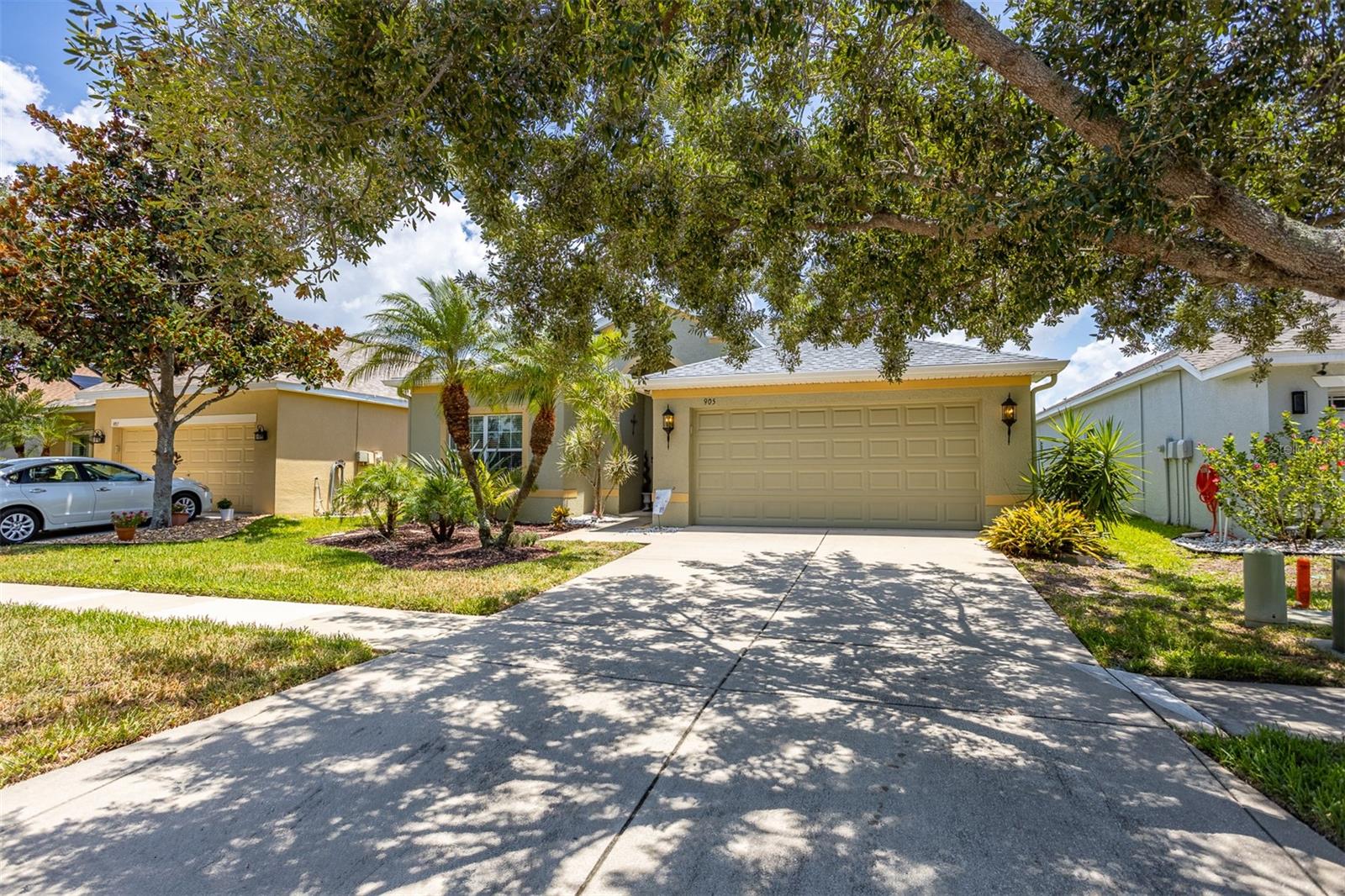 Double car garage and doule wide driveway shaded by mature oak