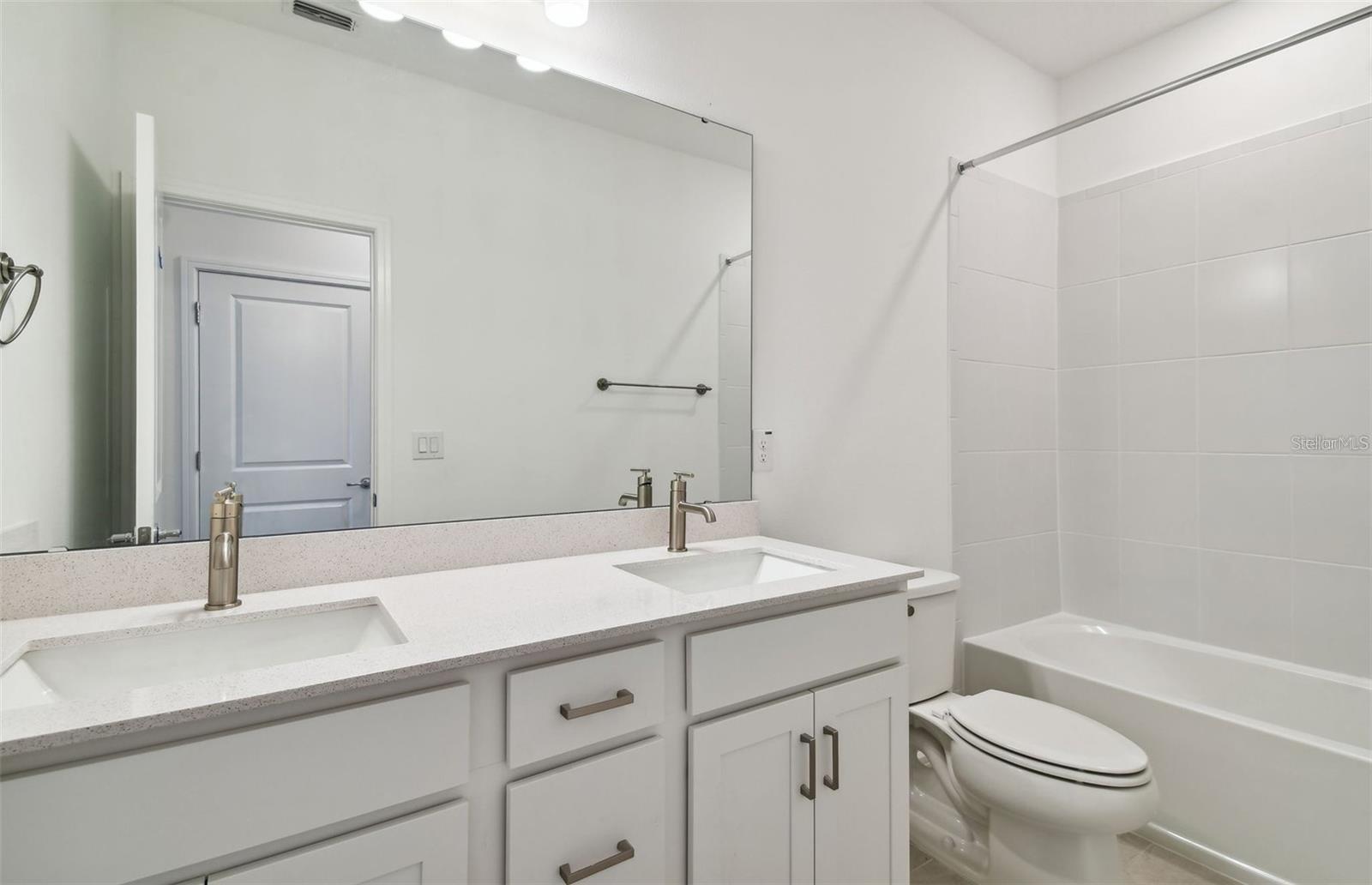 Upstairs hall bathroom with double Quartz sink vanity and shower/tub combo