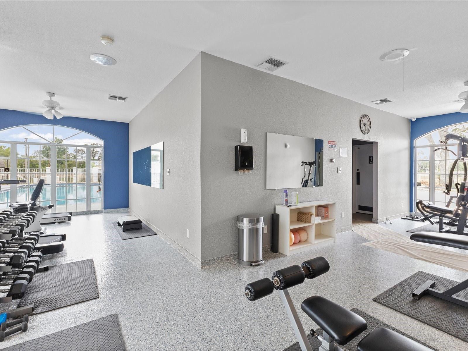 Workout room with bathrooms connected and entrance to the pool
