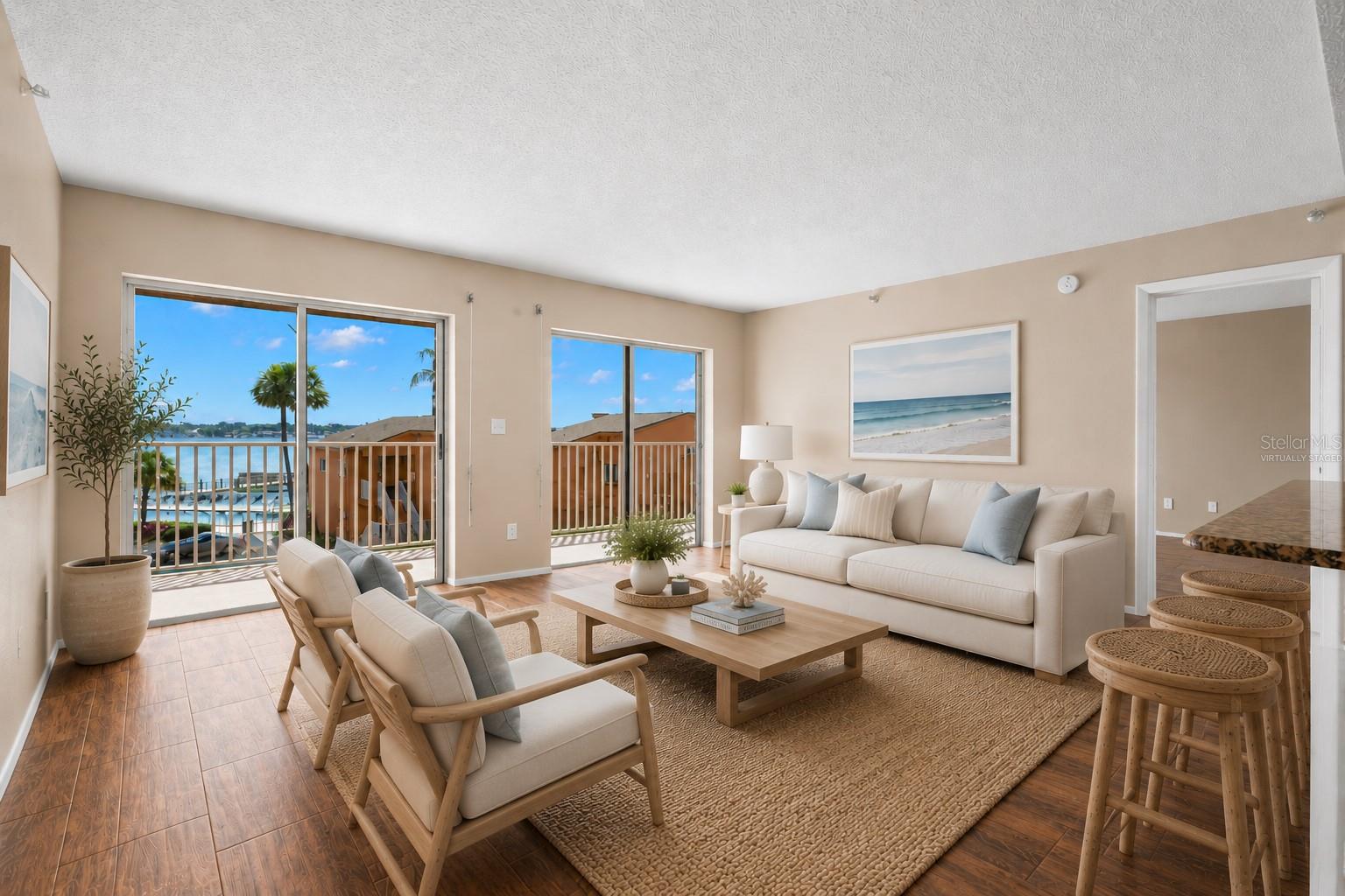 Living room with views of the pool and Tampa bay. (Virtually Staged)