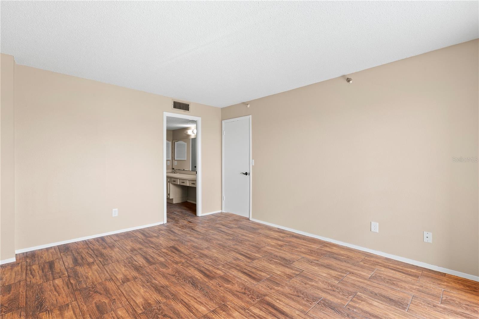 Owners Suite 1 with dressing area, full bathroom with walk-in closet, tub, loo and vanity.