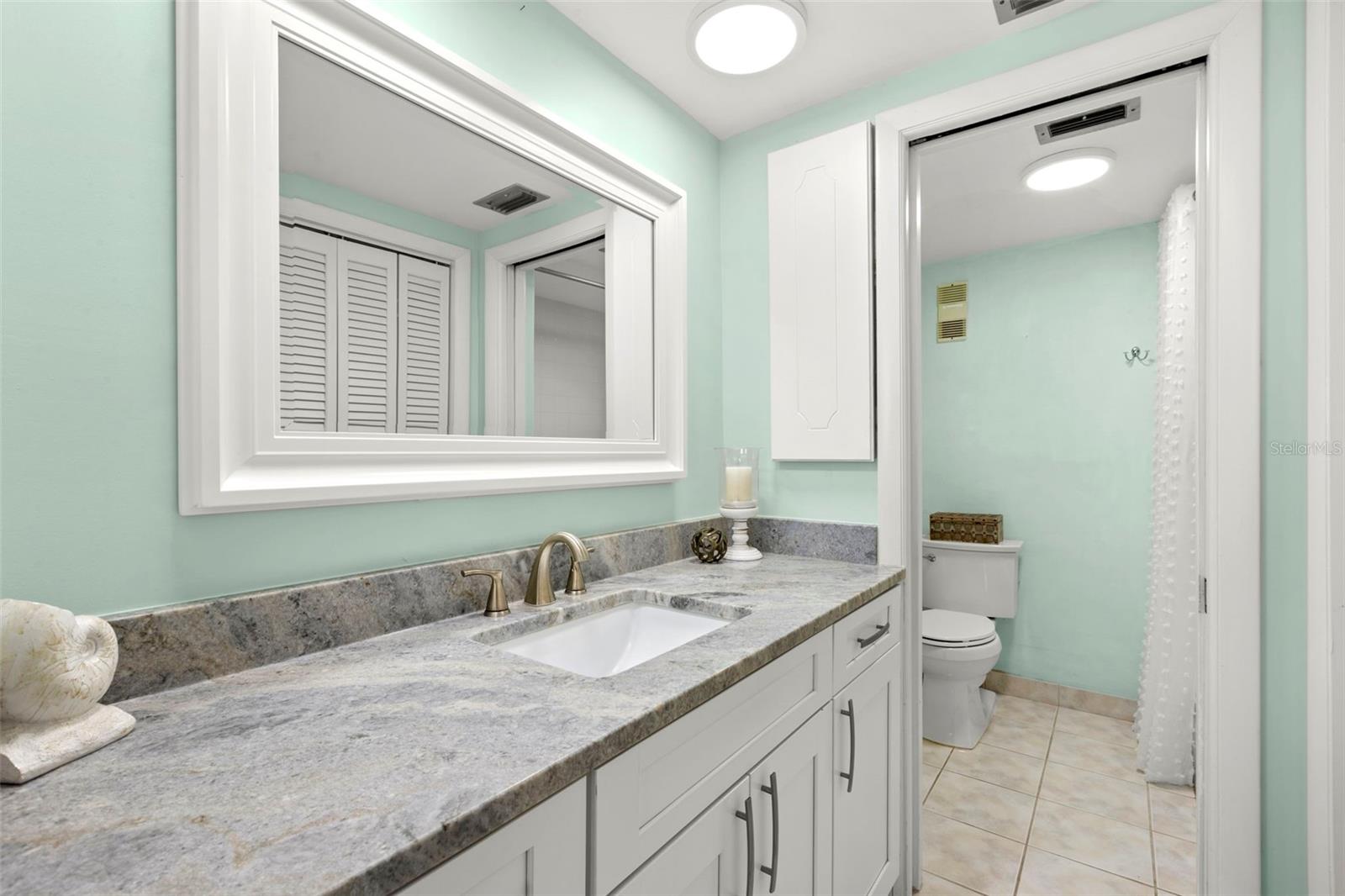 Bedroom 1 ensuite bath with dual sinks, dual closets, tub/shower combo and loo.