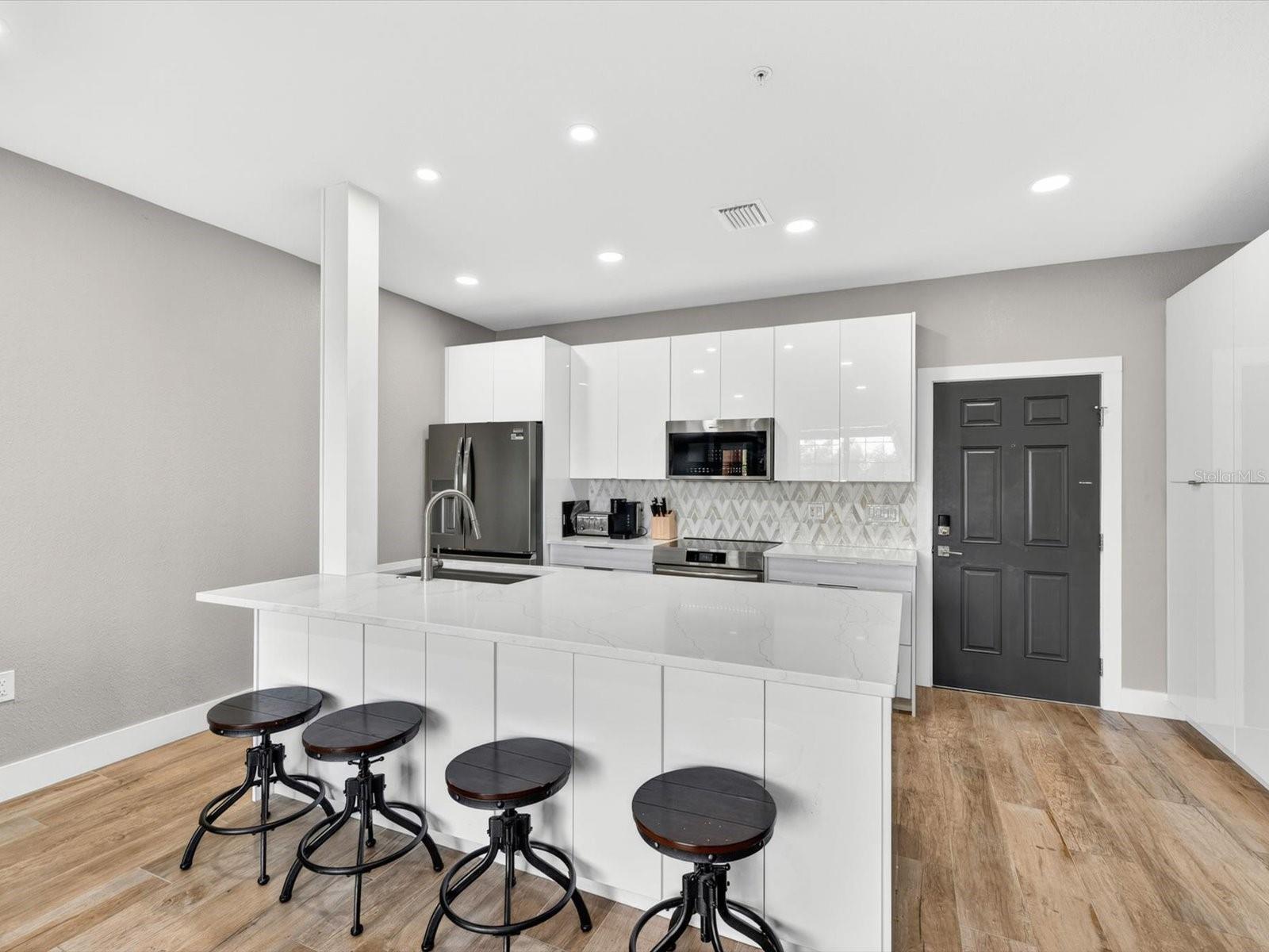 Completely renovated by General Contractor, custom kitchen w/modern gloss cabinetry and quartz counters