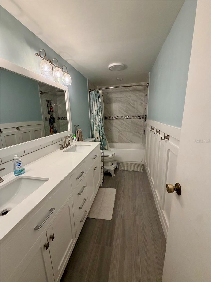 Upstairs bathroom with double sinks and lots of storage! Gorgeous tile in the bathtub and beautiful wood-look ceramic tile