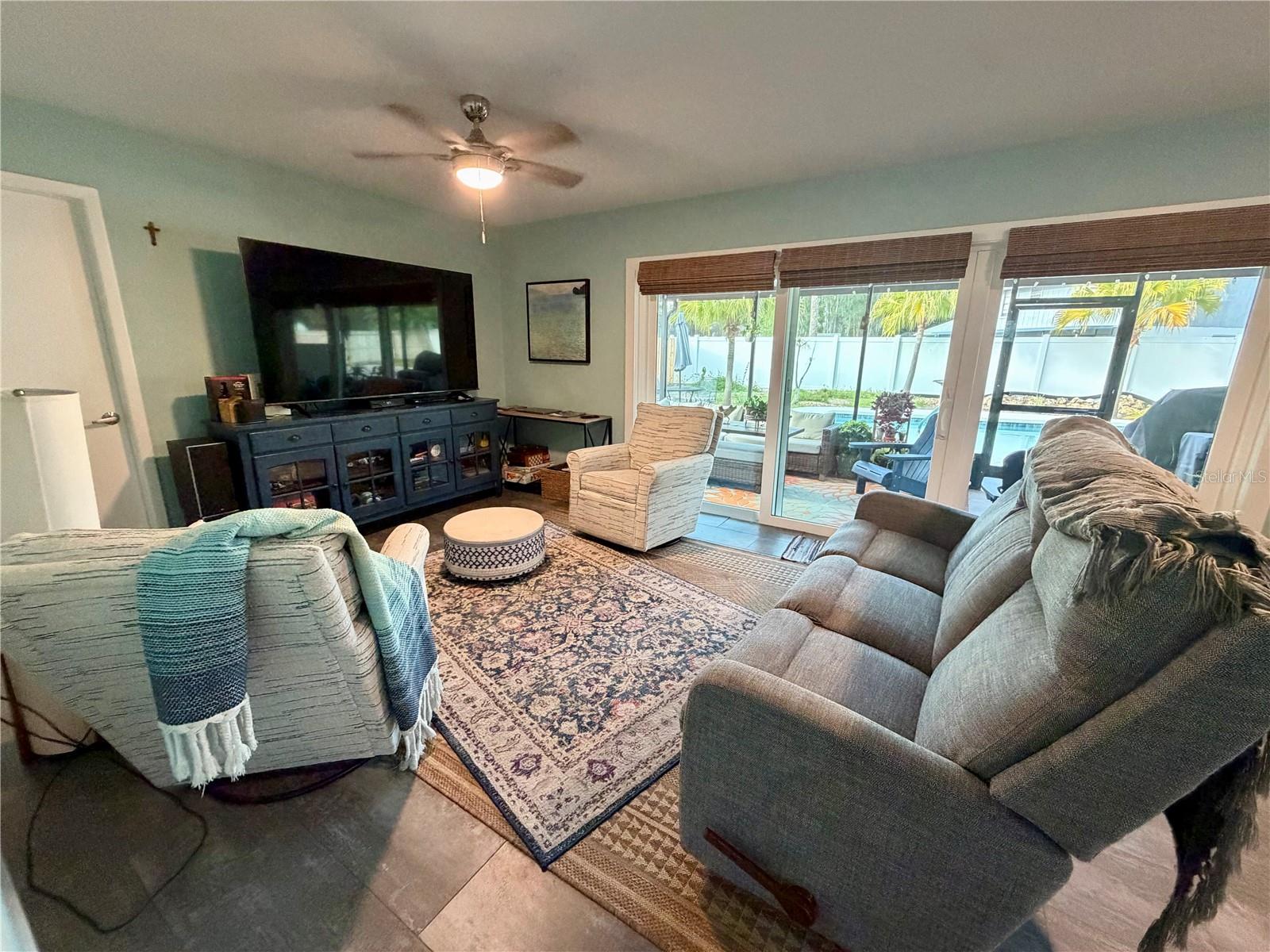 Versatile family room overlooking the patio and pool