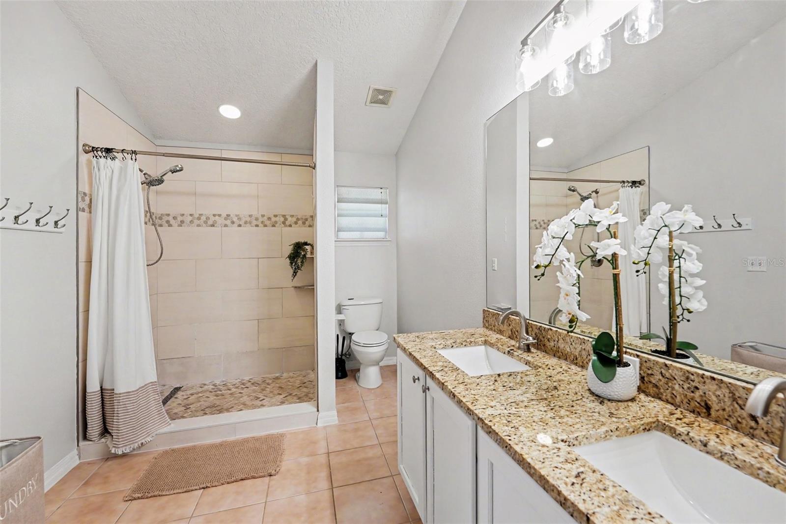 Walk-in shower and double sinks with granite tops